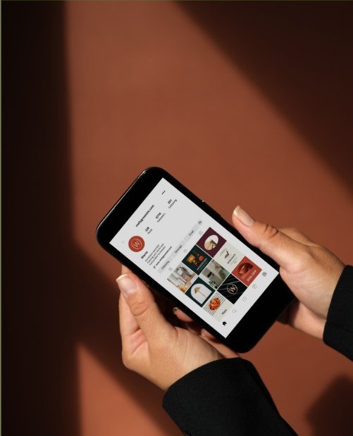 A hand holding a phone with a social media feed open